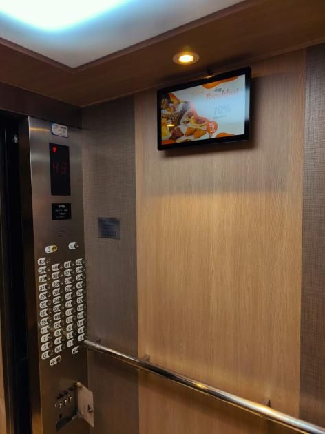 15.6-inch landscape screen showing Café Premiere promotions in a City Premiere lift