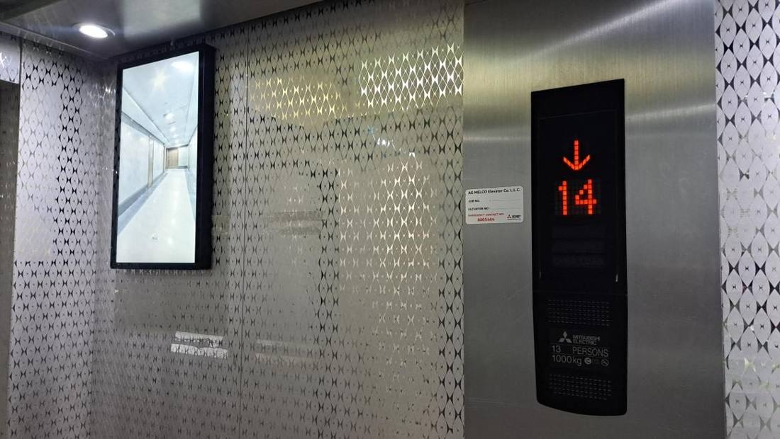 22-inch portrait digital screen installed beside a Mitsubishi lift panel at RHA, Ajman